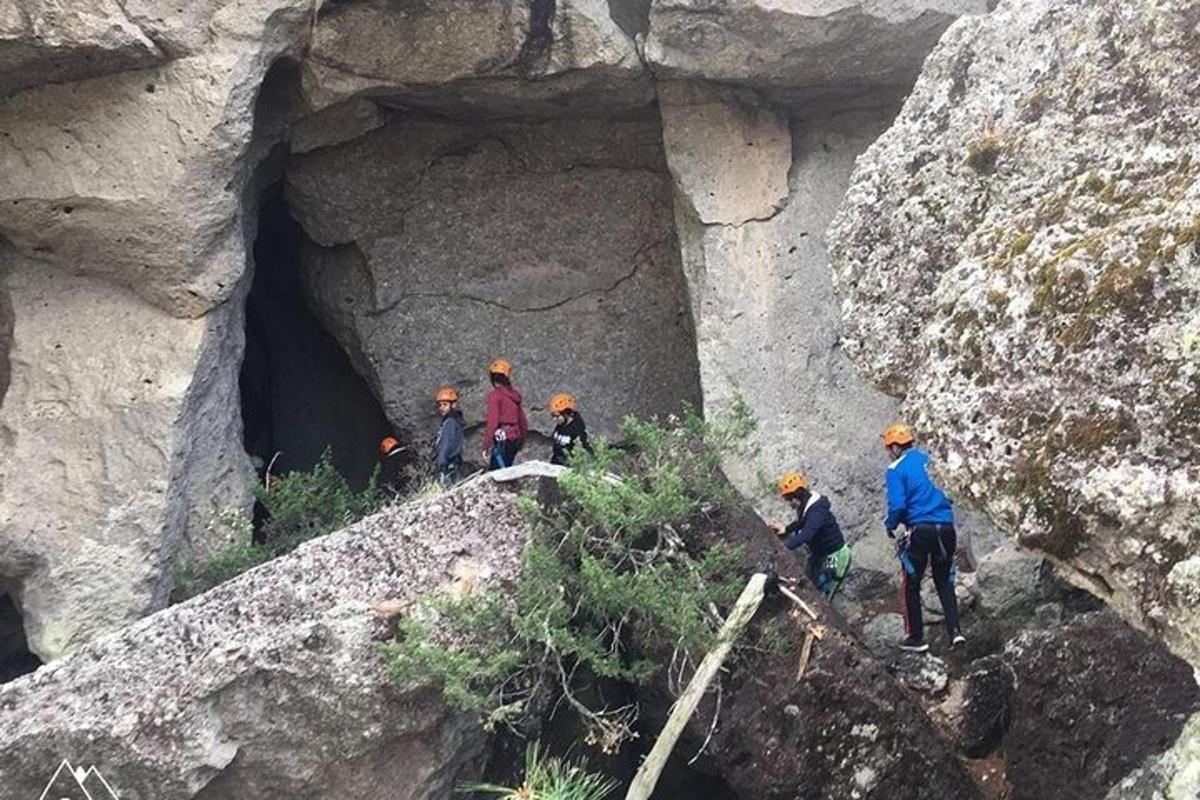 a group of people walking through a rock cave