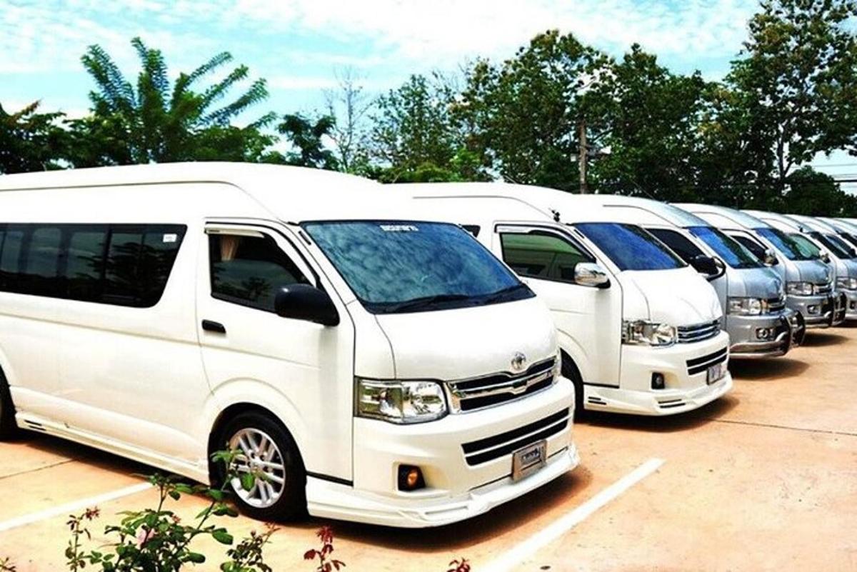 a row of white vans parked in a parking lot