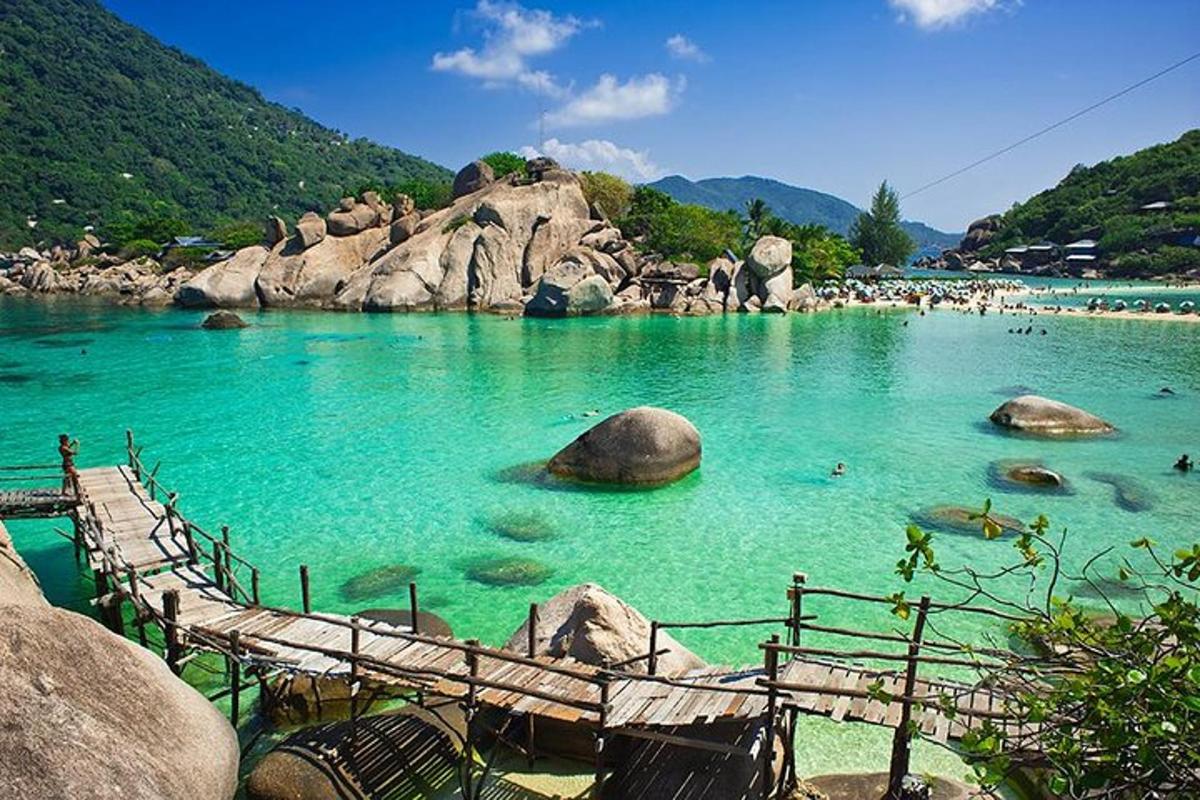 o piscină cu apă albastră cu pietre și oameni în ea