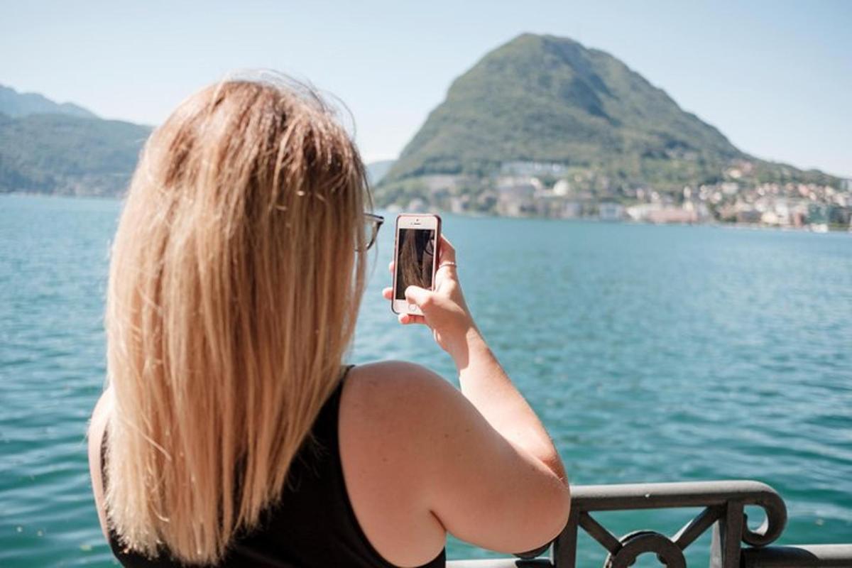 en kvinne som tar et bilde av vannet med mobiltelefonen sin