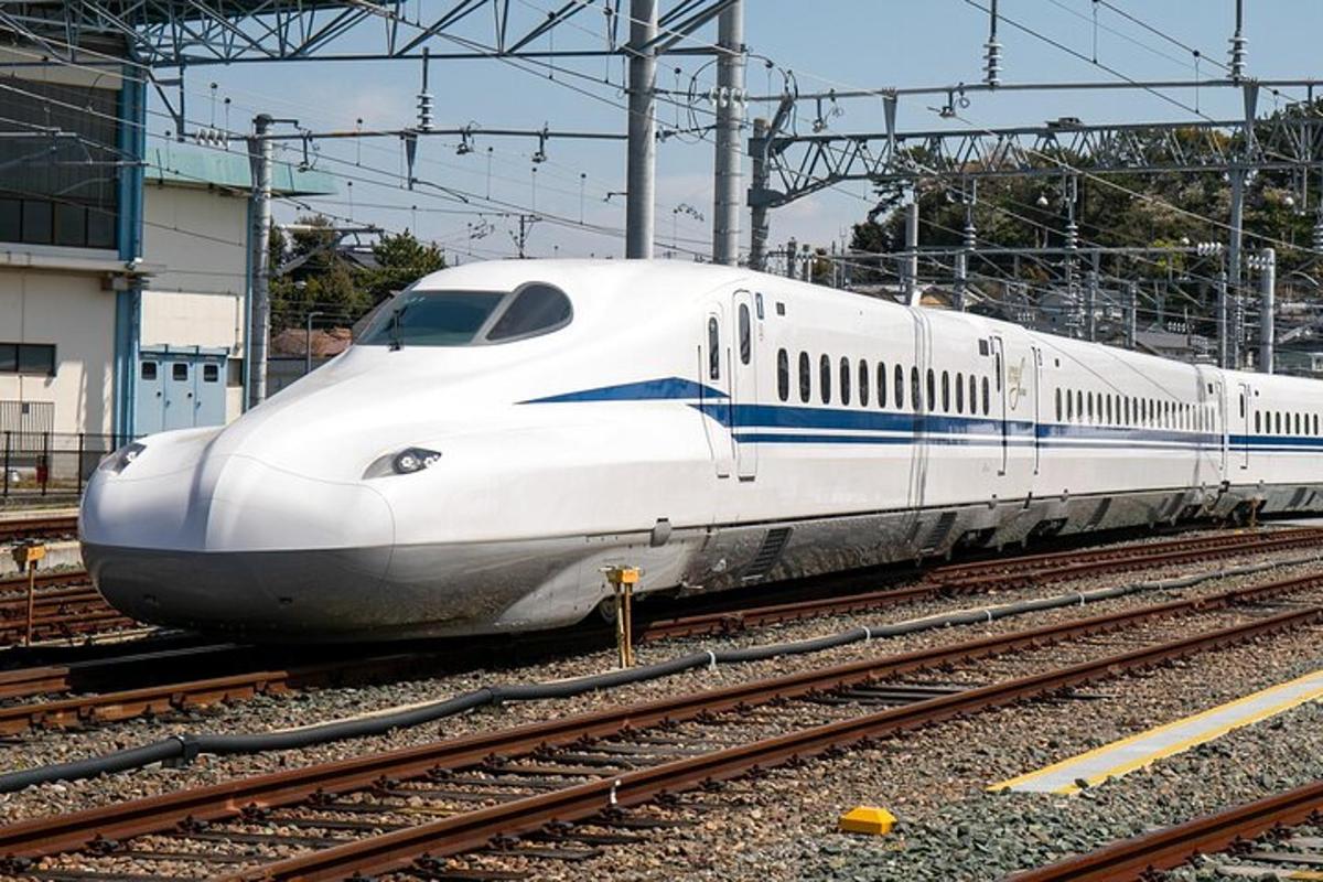 a white bullet train is on the tracks