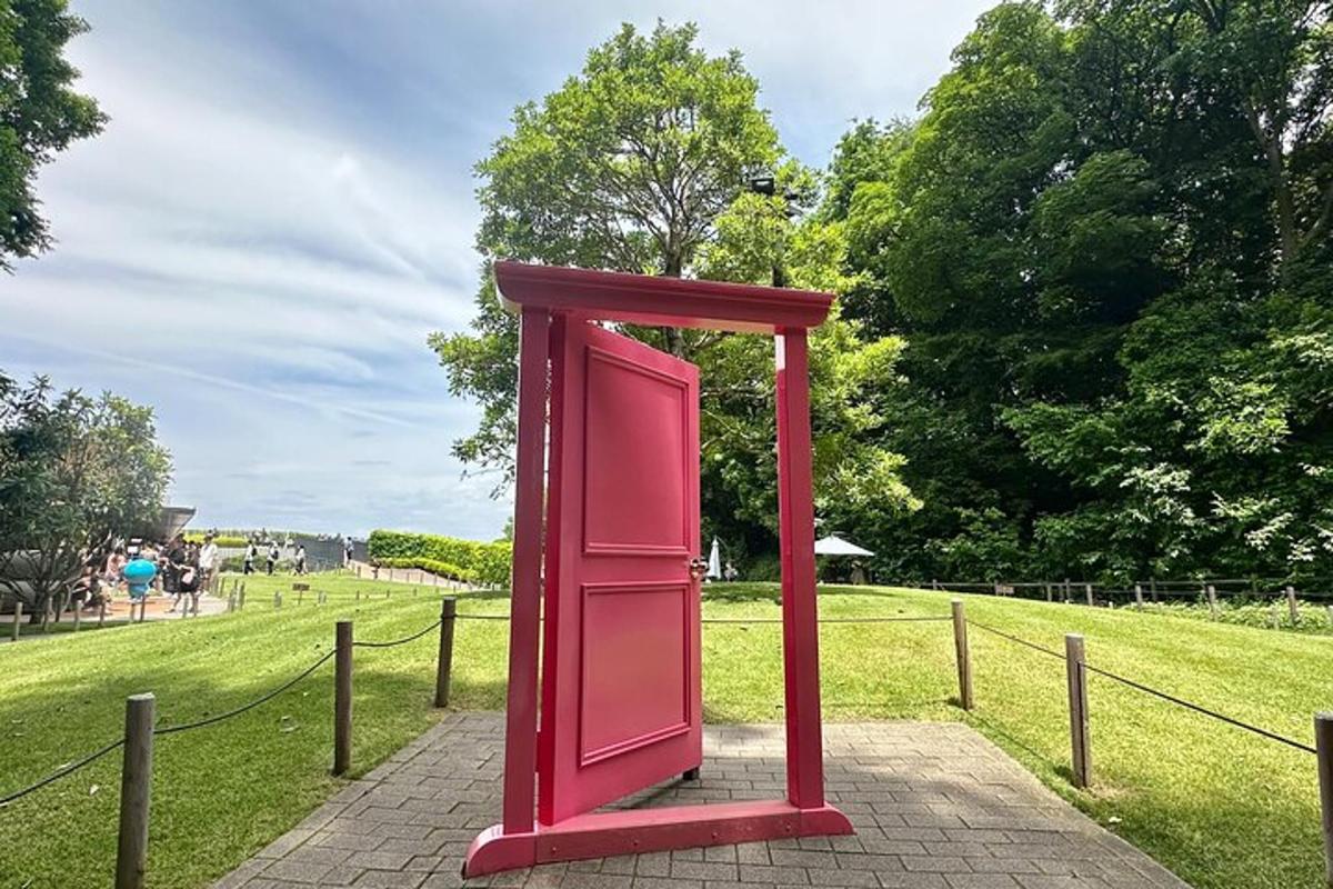 a red phone booth sitting in a park
