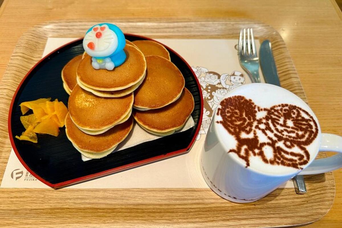 a plate of pancakes next to a cup of coffee