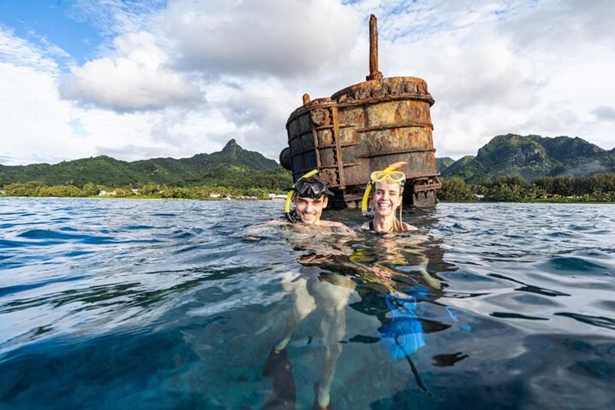 two people in the water in front of a boat