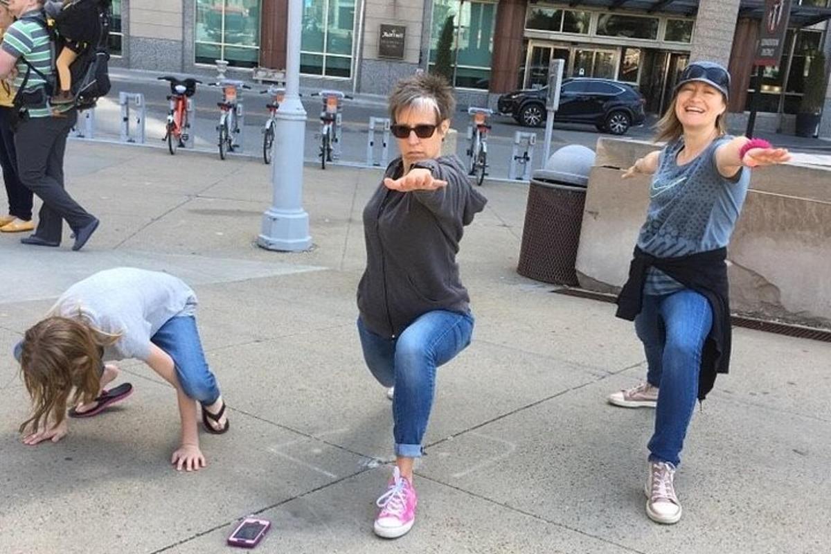 two girls are playing on the sidewalk with their cell phones