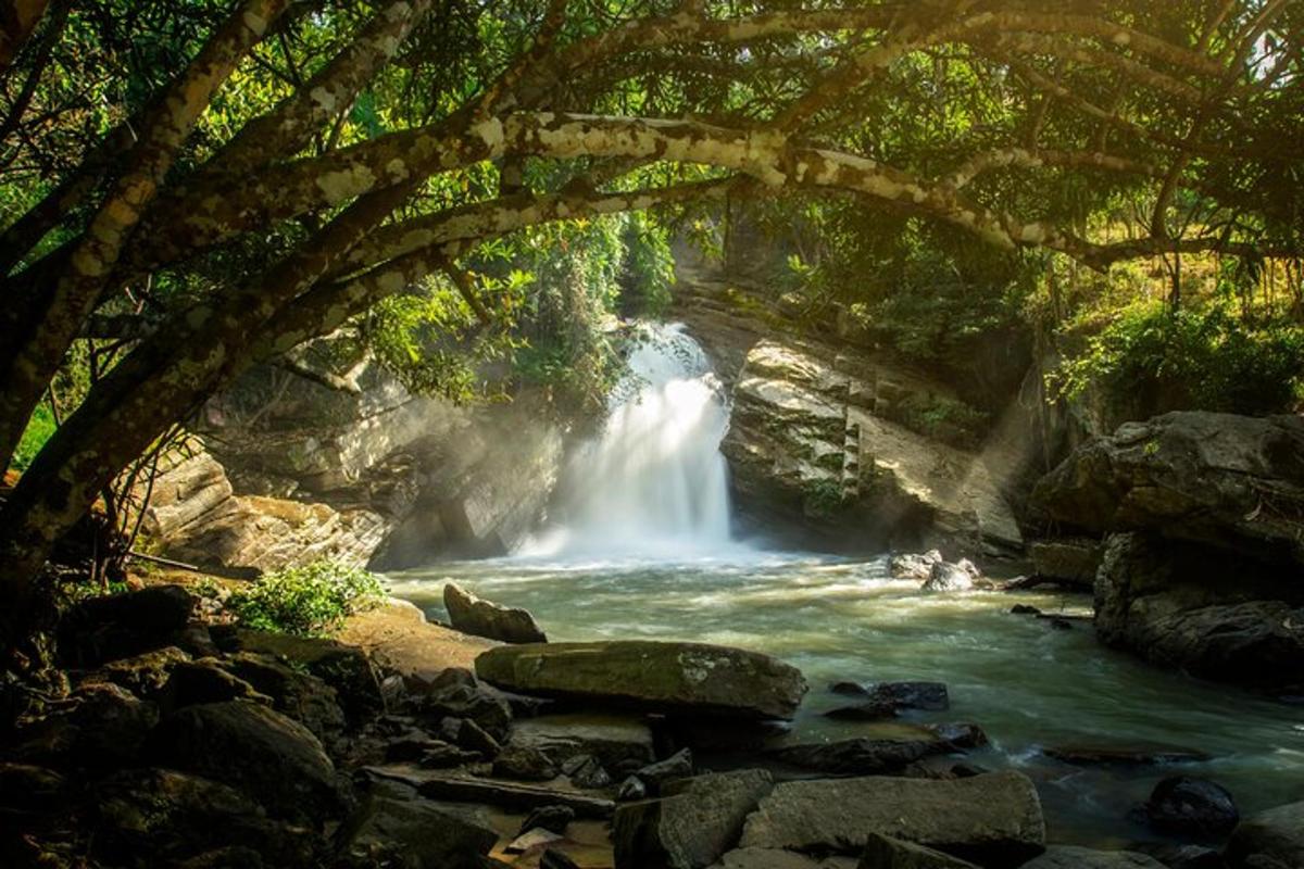 a waterfall under a bridge over a river
