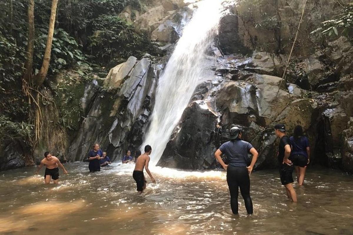 un gruppo di persone in acqua vicino a una cascata