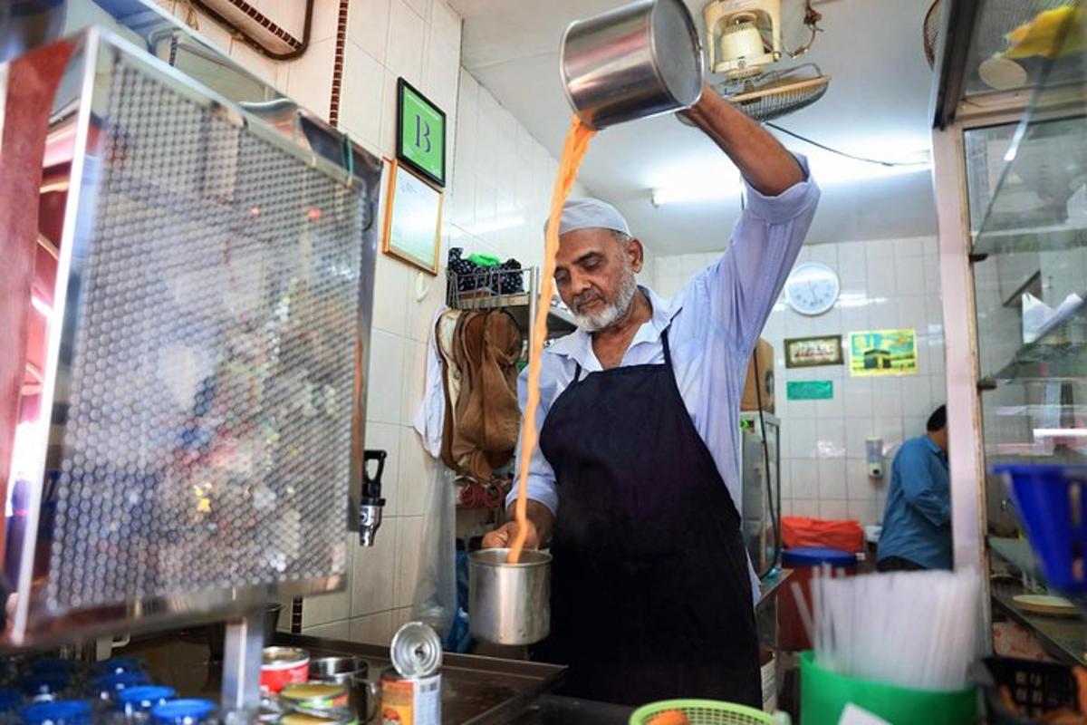 un home a la cuina sostenint una olla