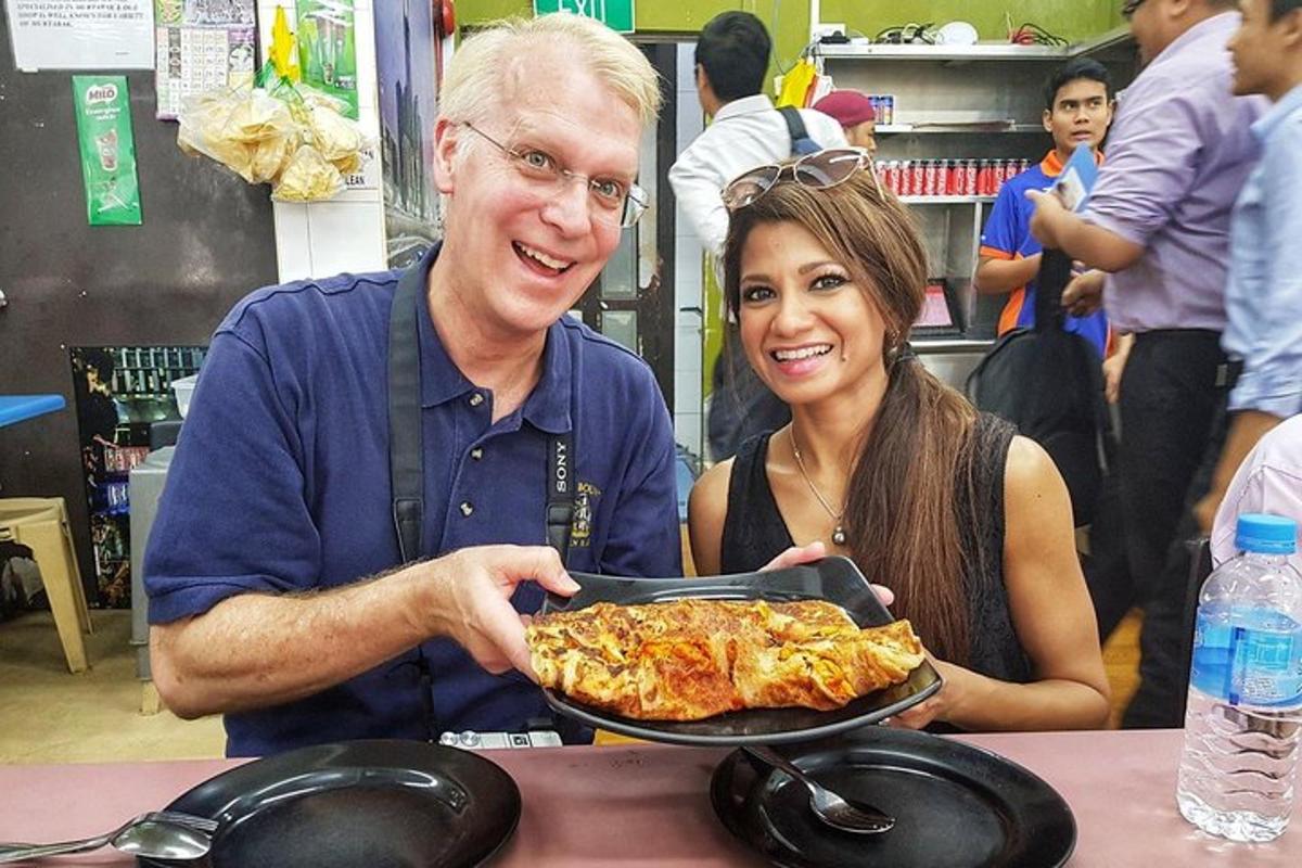 Un hombre y una mujer sosteniendo un plato de pizza