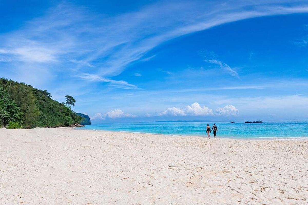 due persone che camminano su una spiaggia vicino all'oceano