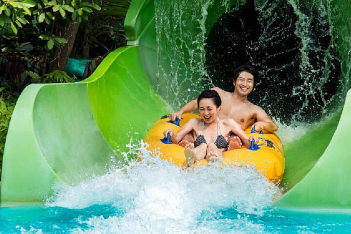 a man and a woman riding on a water slide