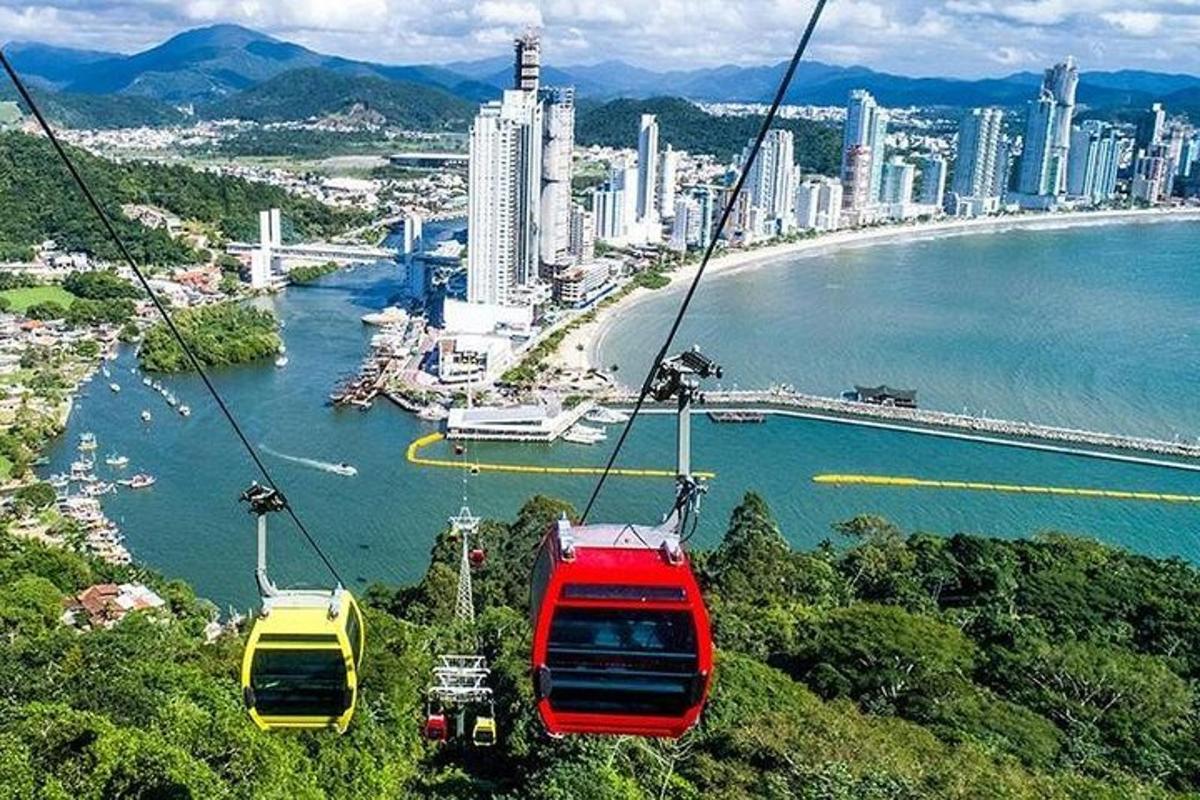 three gondolas on a cable car over a city