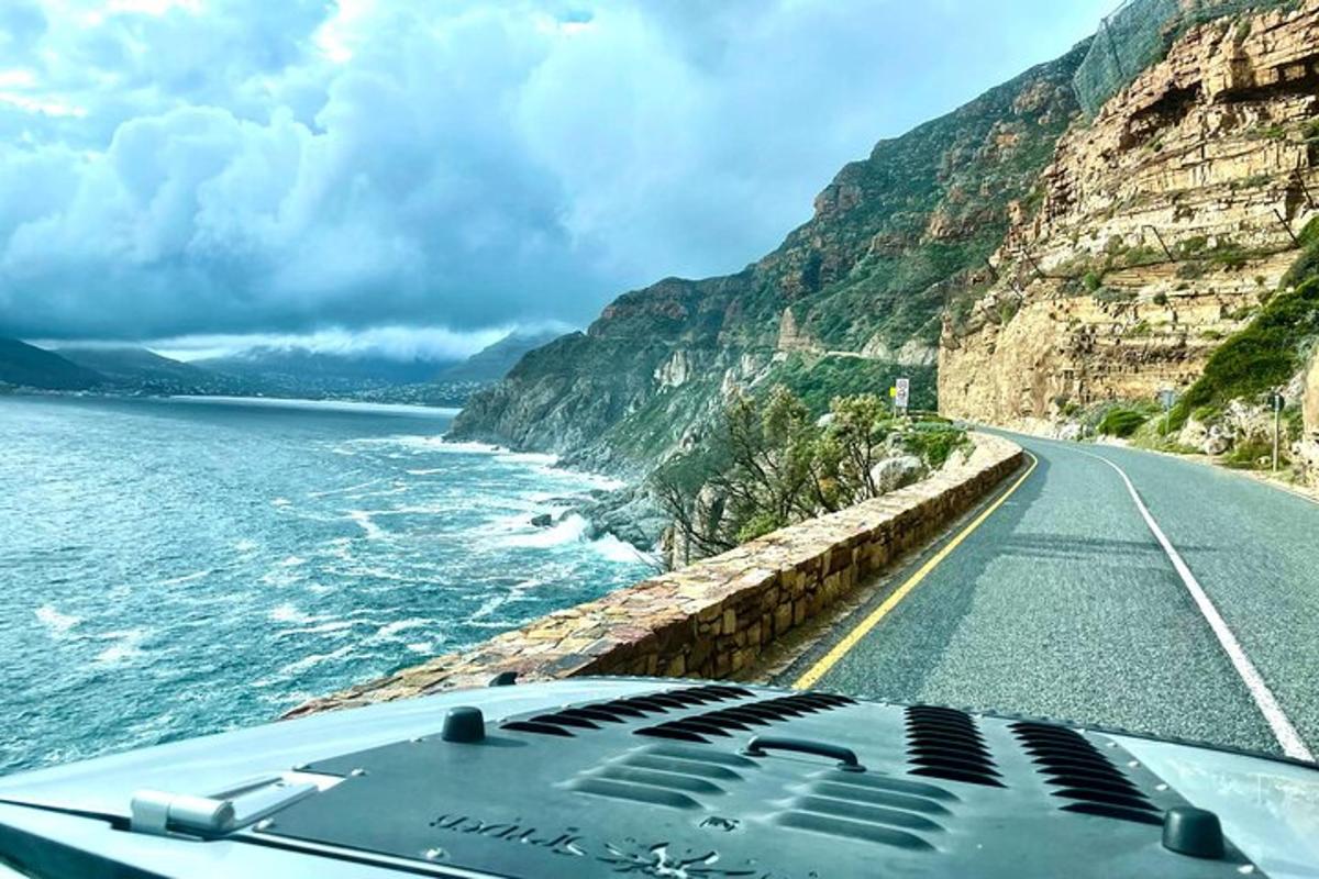 un'auto che percorre una strada vicino all'oceano