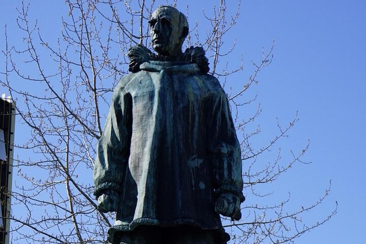 egy fa mellett álló férfi szobra