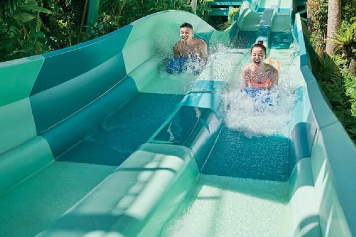 two people riding a slide in a water park