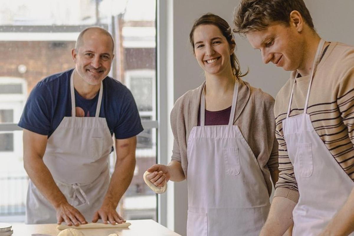 two men and a woman in a kitchen preparing food