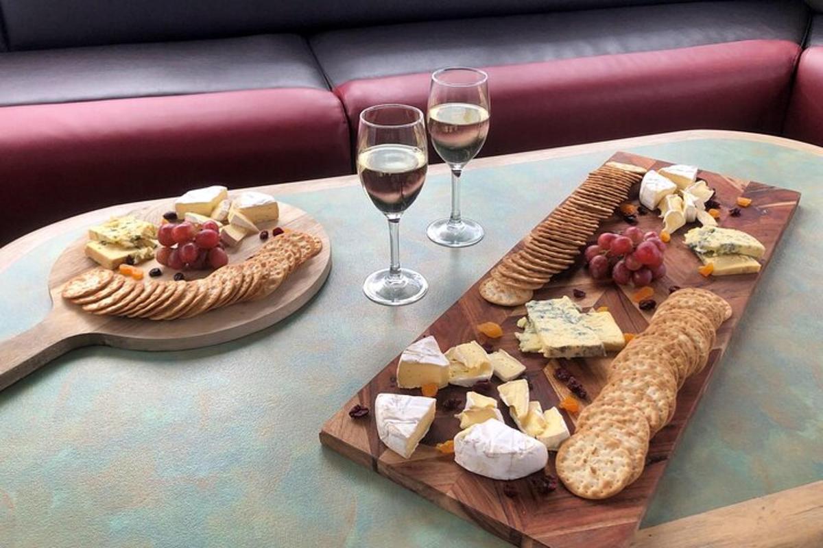 a table with wine glasses and cheese and crackers