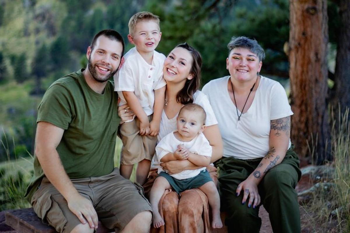 une famille pose pour une photo en tenant un bébé