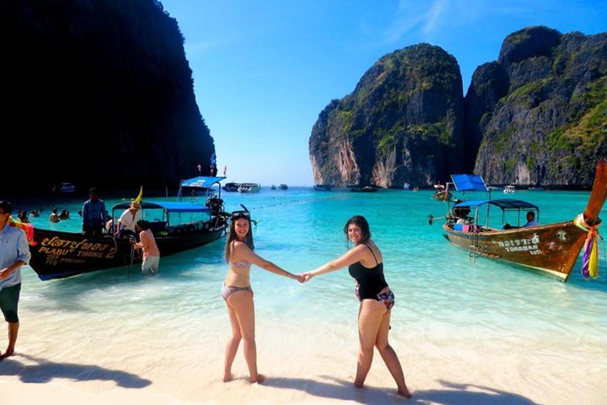 two women standing on a beach holding hands