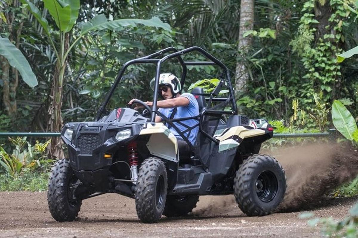 um homem andando de quadriciclo em uma estrada de terra