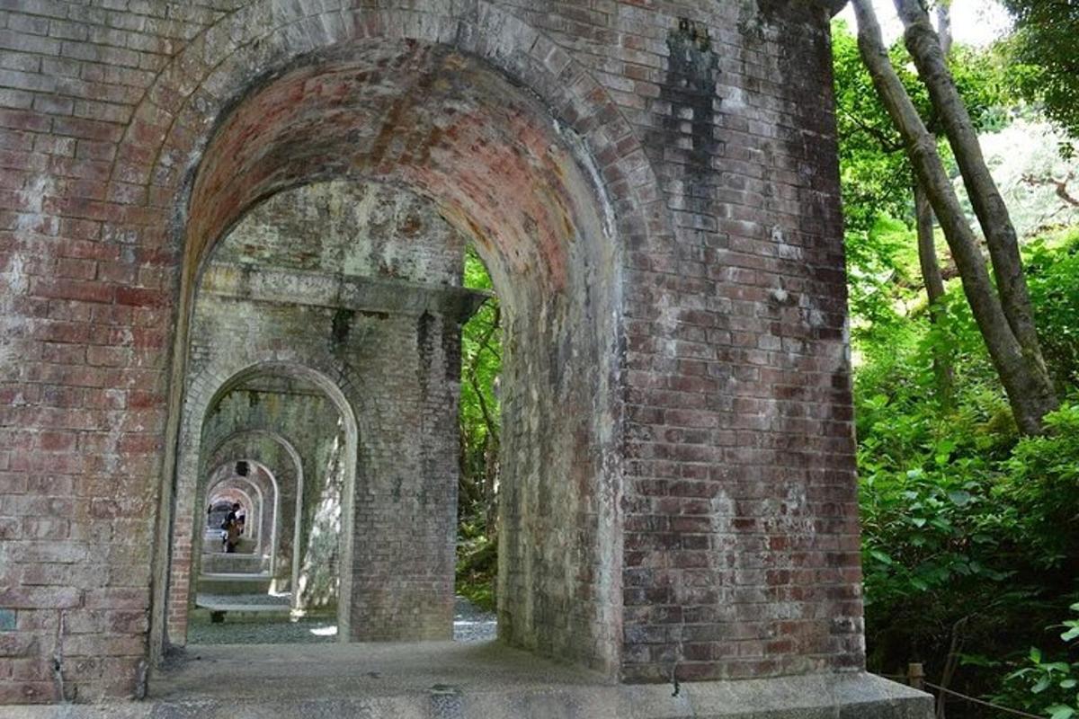 un arco in un muro di mattoni con una persona che lo attraversa