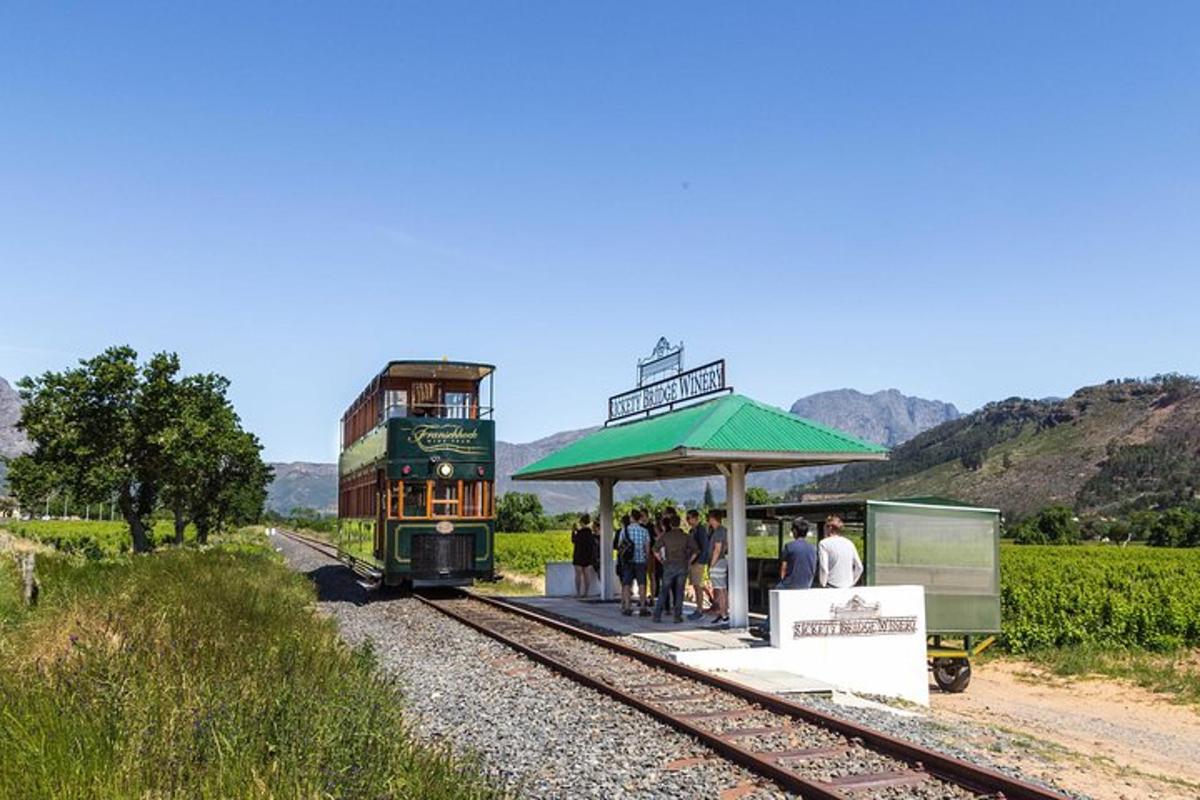 Un tren se detuvo en una estación de tren con gente esperando.