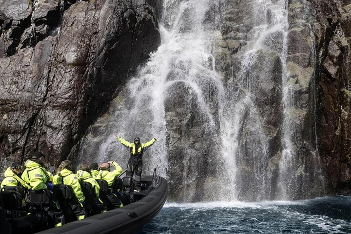 um grupo de pessoas em uma jangada em frente a uma cachoeira