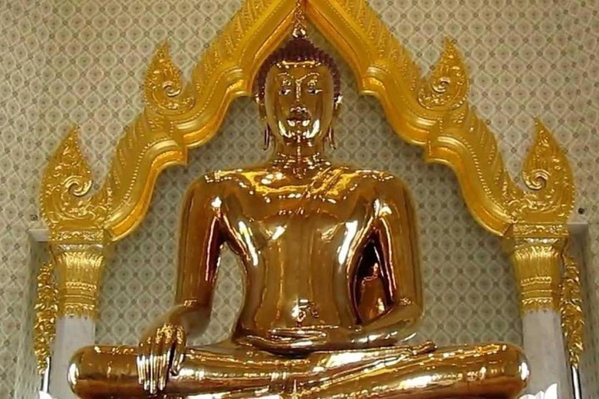 una statua di Buddha d'oro seduta su un tavolo