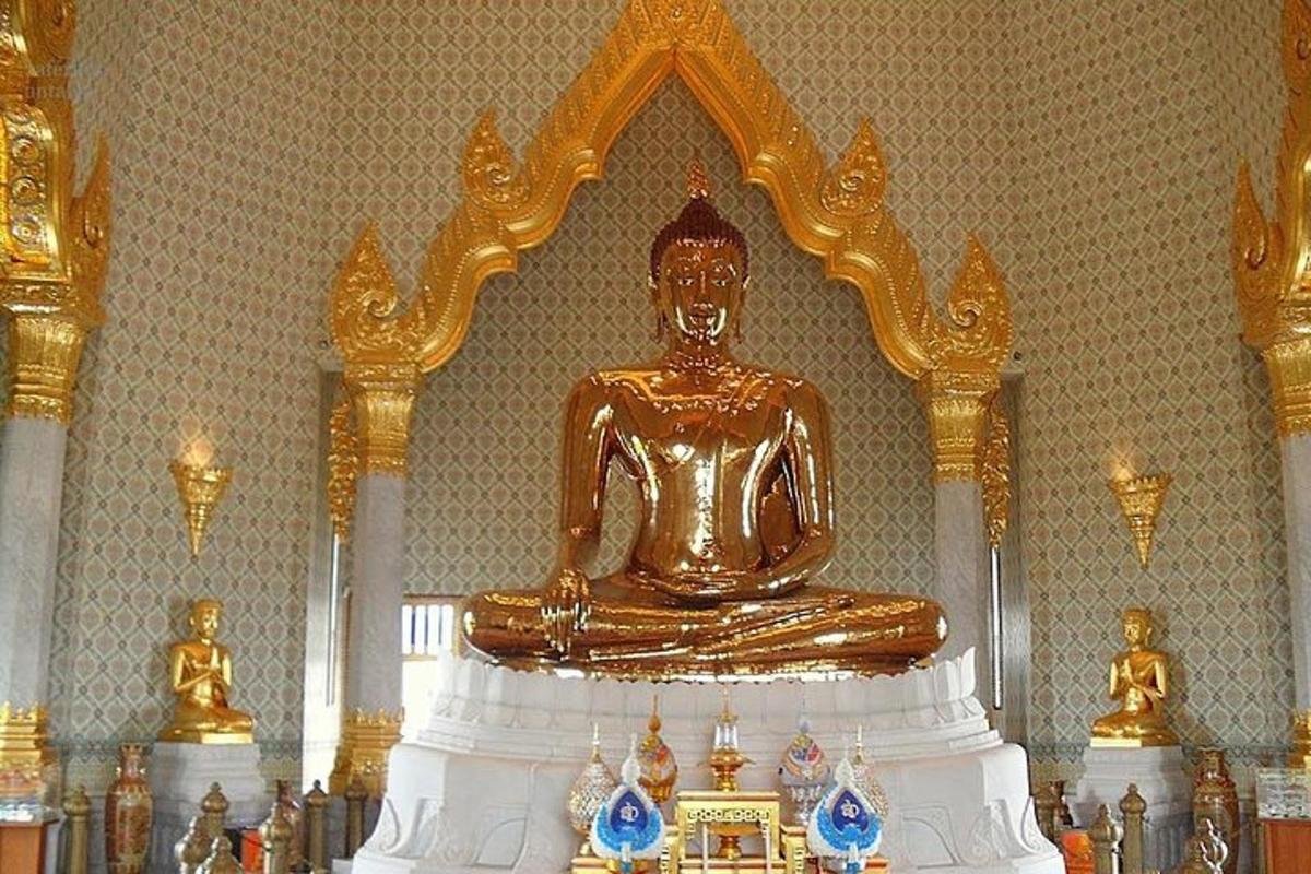 una grande statua dorata del Buddha seduta su un tavolo