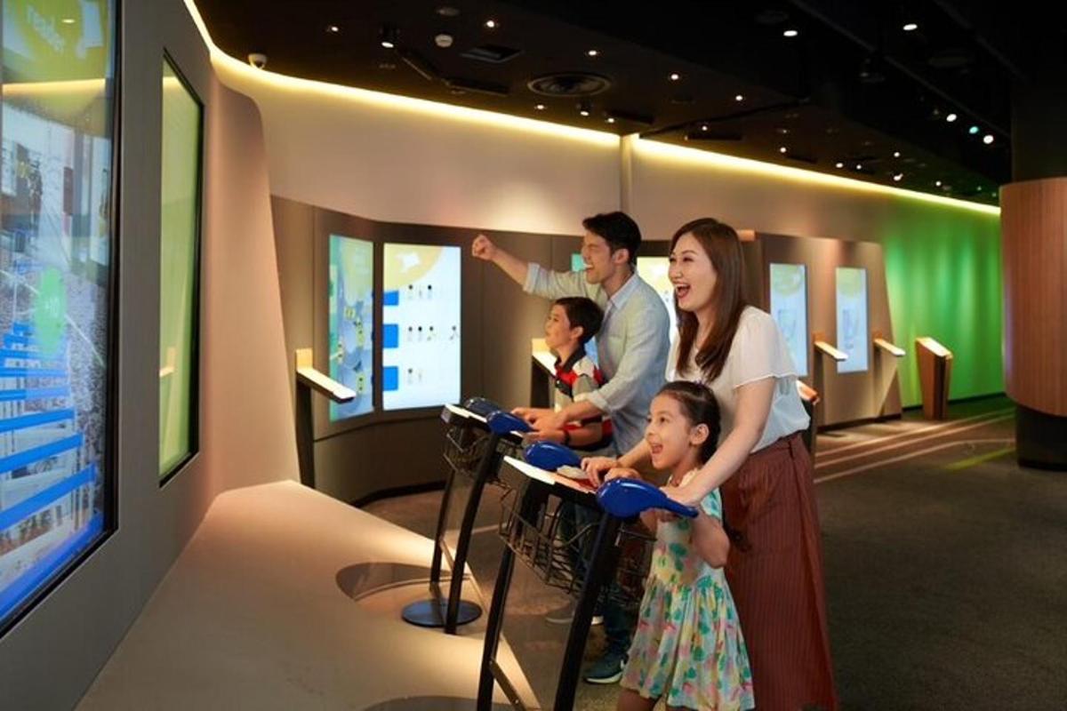 Una familia parada frente a un televisor en un museo.