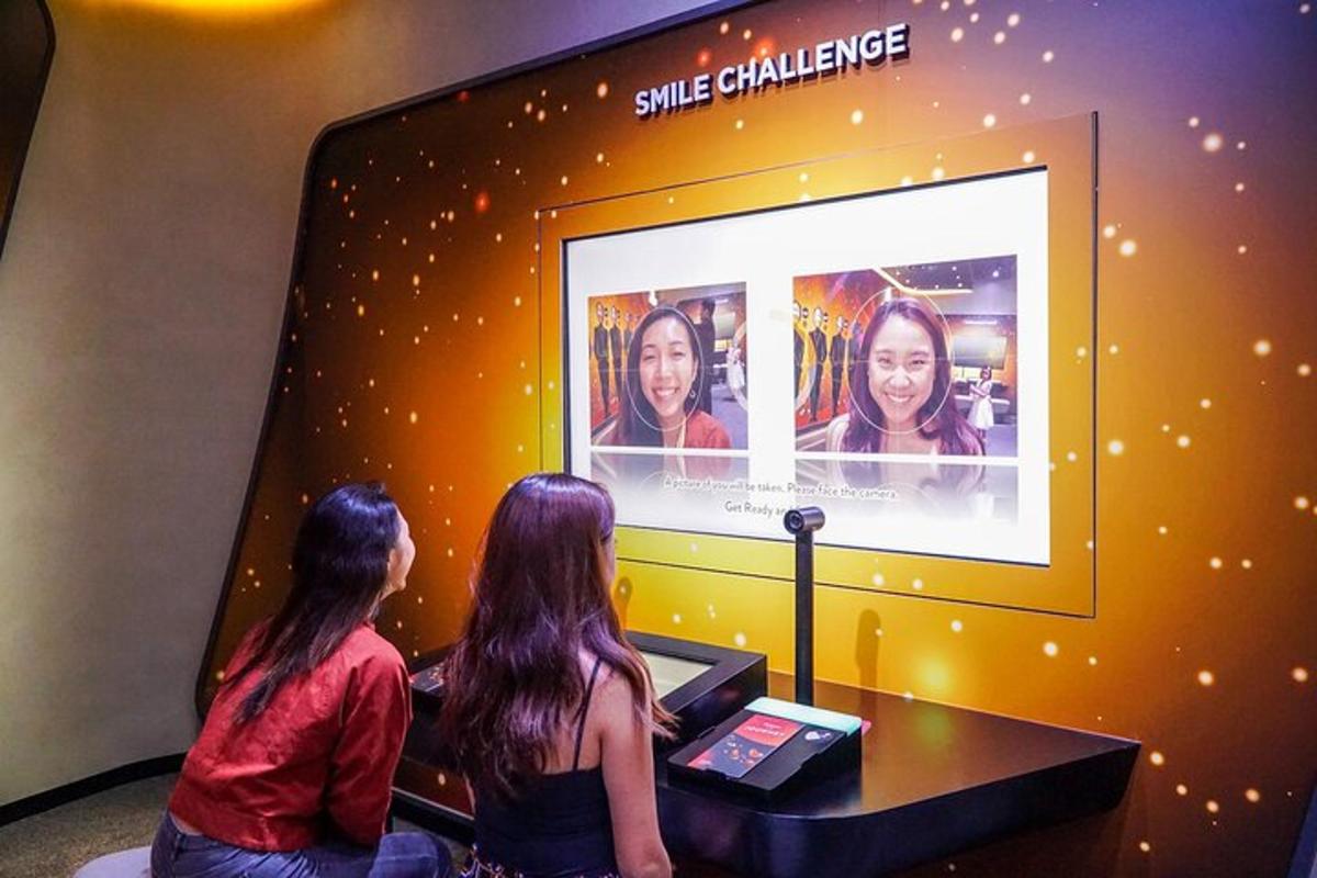 two women sitting in front of a video screen