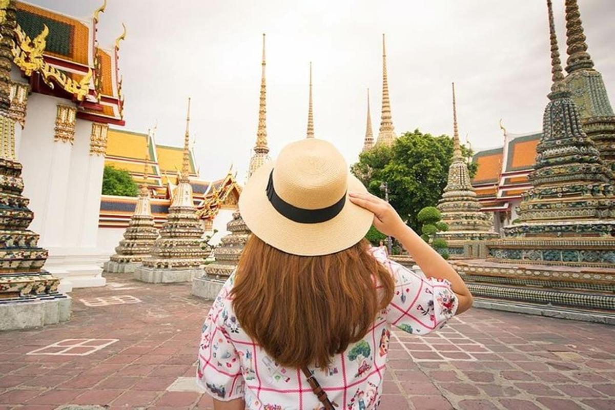 a woman wearing a hat looking at a temple