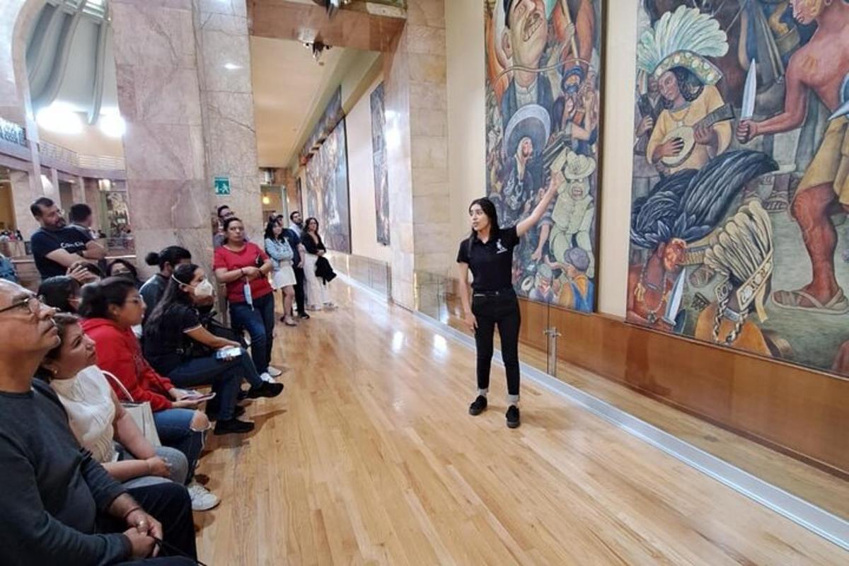 a woman standing in front of a crowd looking at a painting
