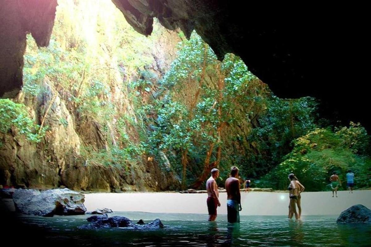 Un grupo de personas de pie en el agua en una cueva.