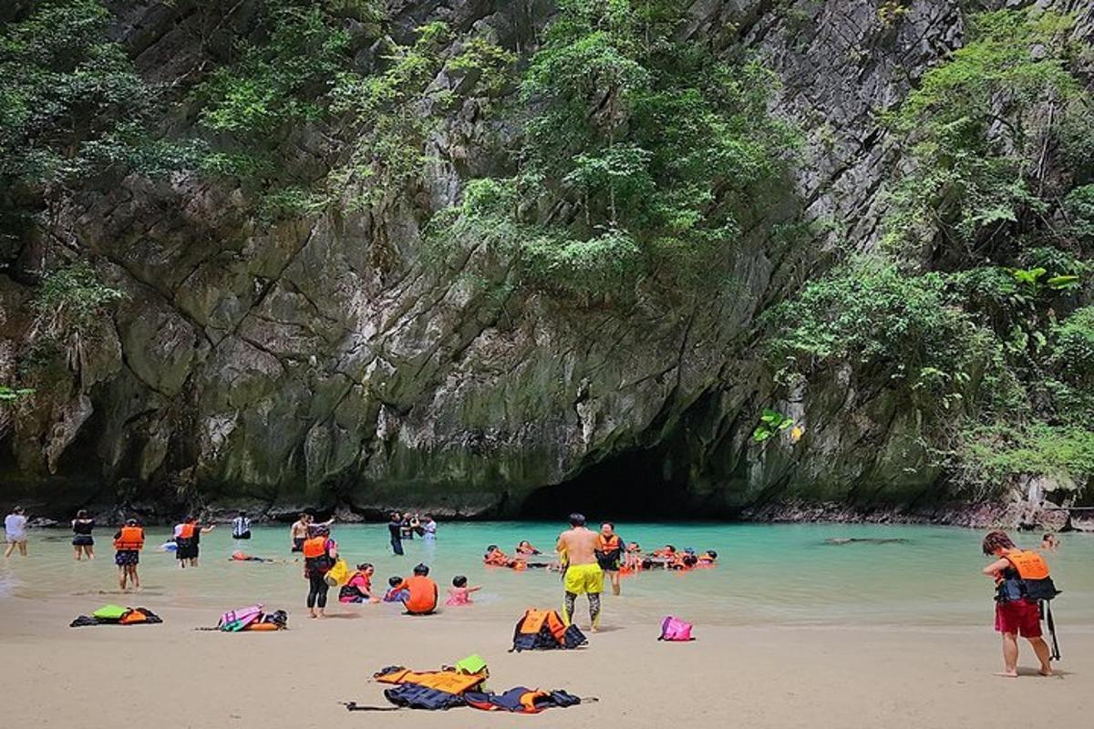 Un grupo de personas en una playa frente a una cueva.