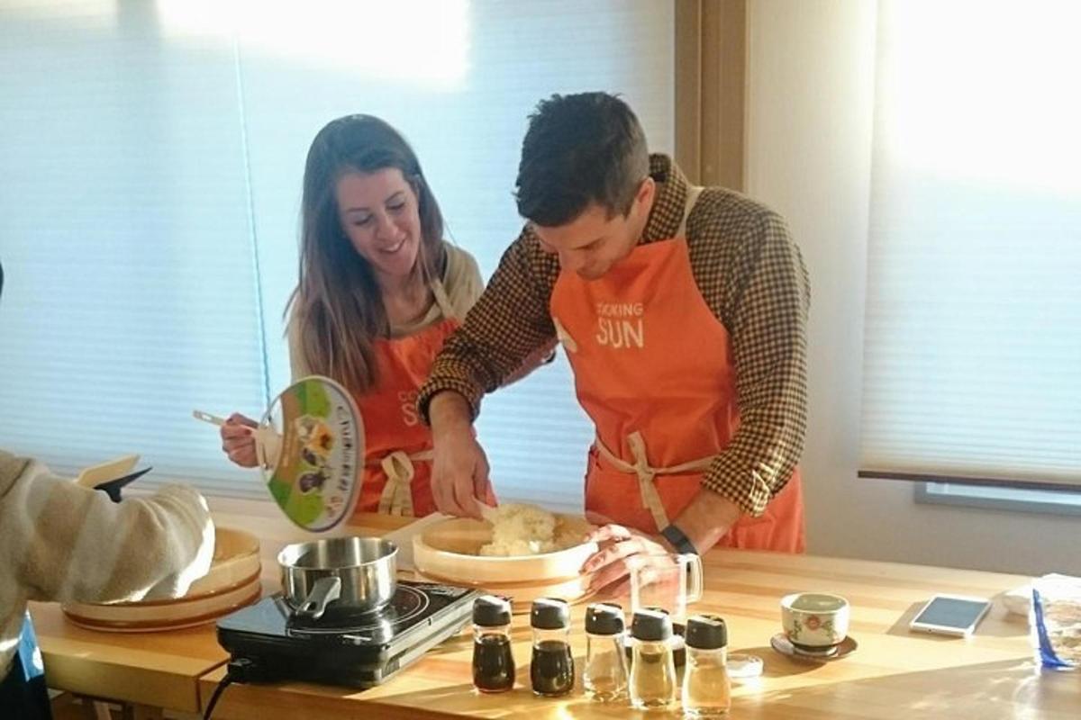 tveir einstaklingar standa í eldhúsi að útbúa mat