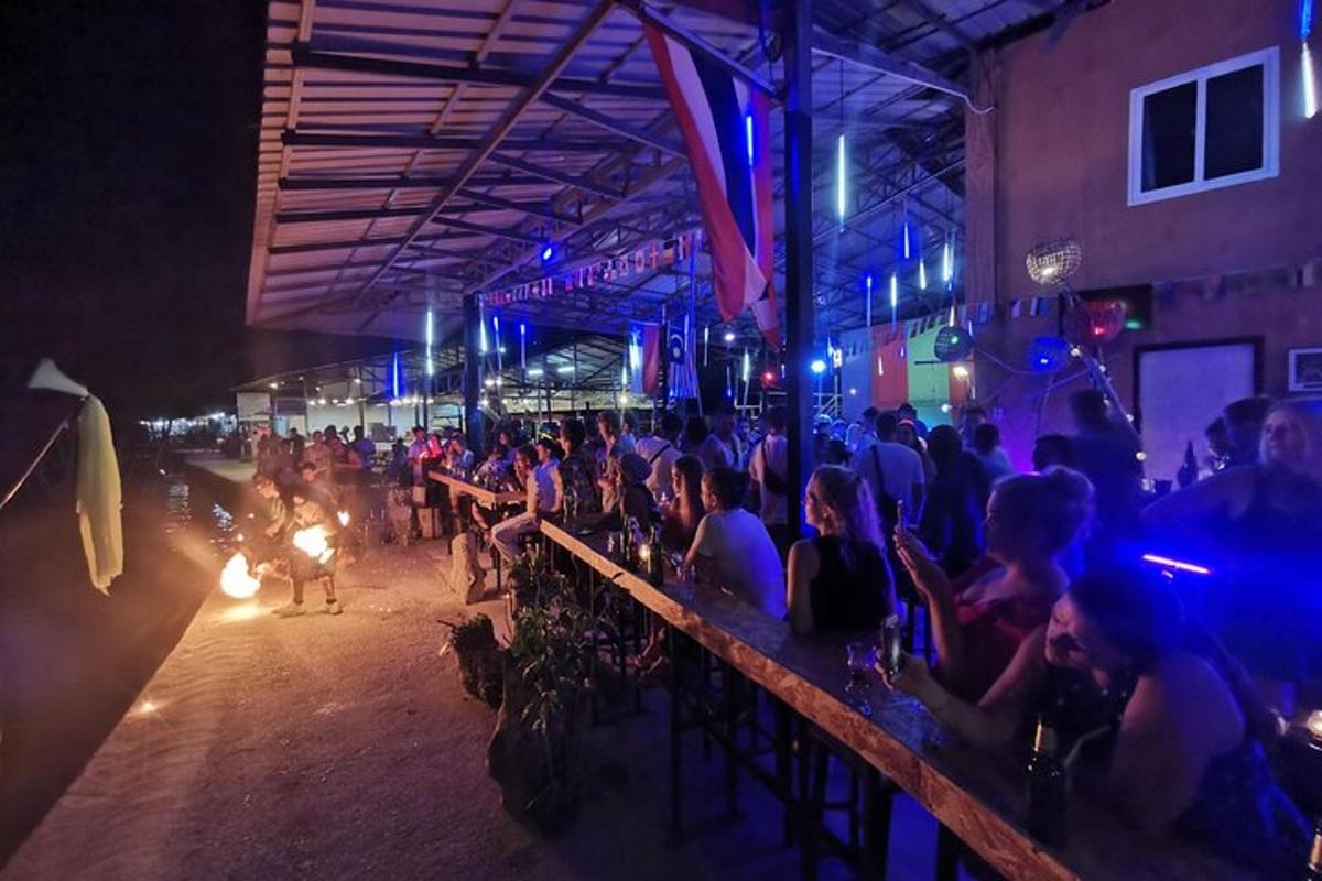 Un grupo de personas sentadas en un bar por la noche.