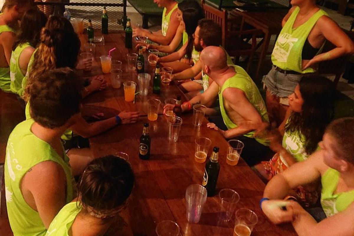 Un grupo de personas sentadas alrededor de una mesa larga con bebidas.