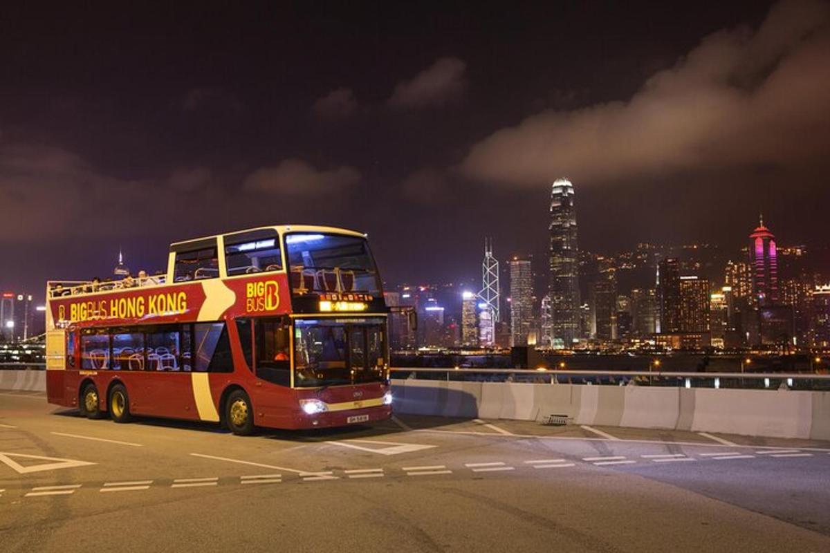 a double decker bus parked in a parking lot at night