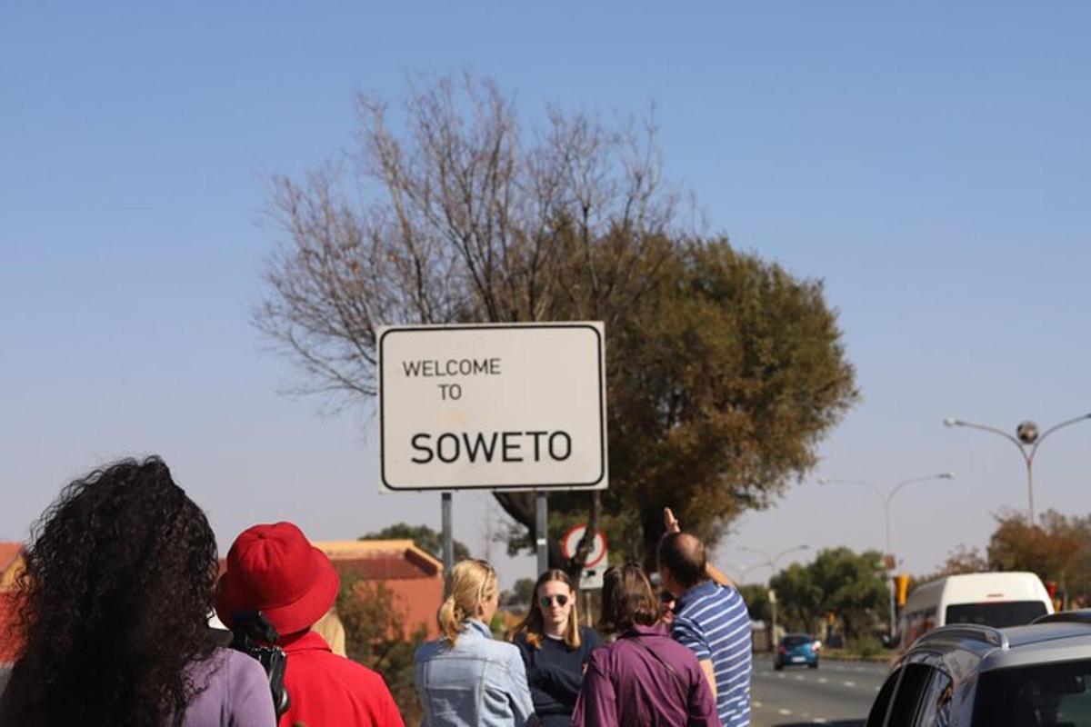 a group of people walking down a street with a sign