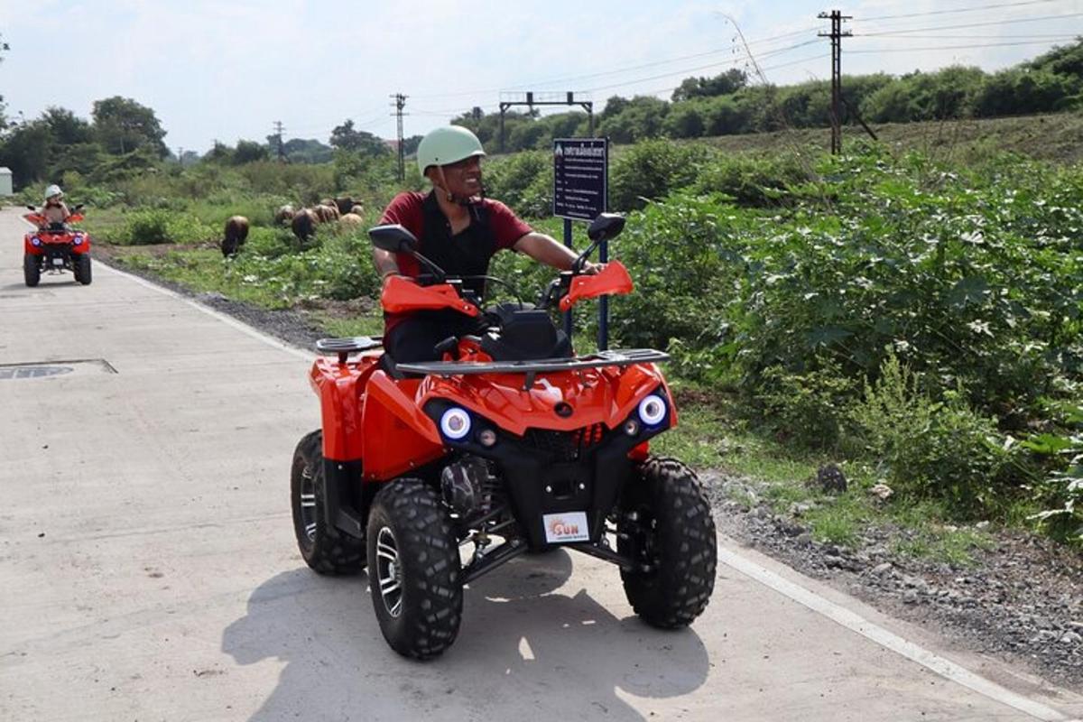seorang lelaki menunggang sebuah kereta empat roda berwarna merah di atas jalan raya
