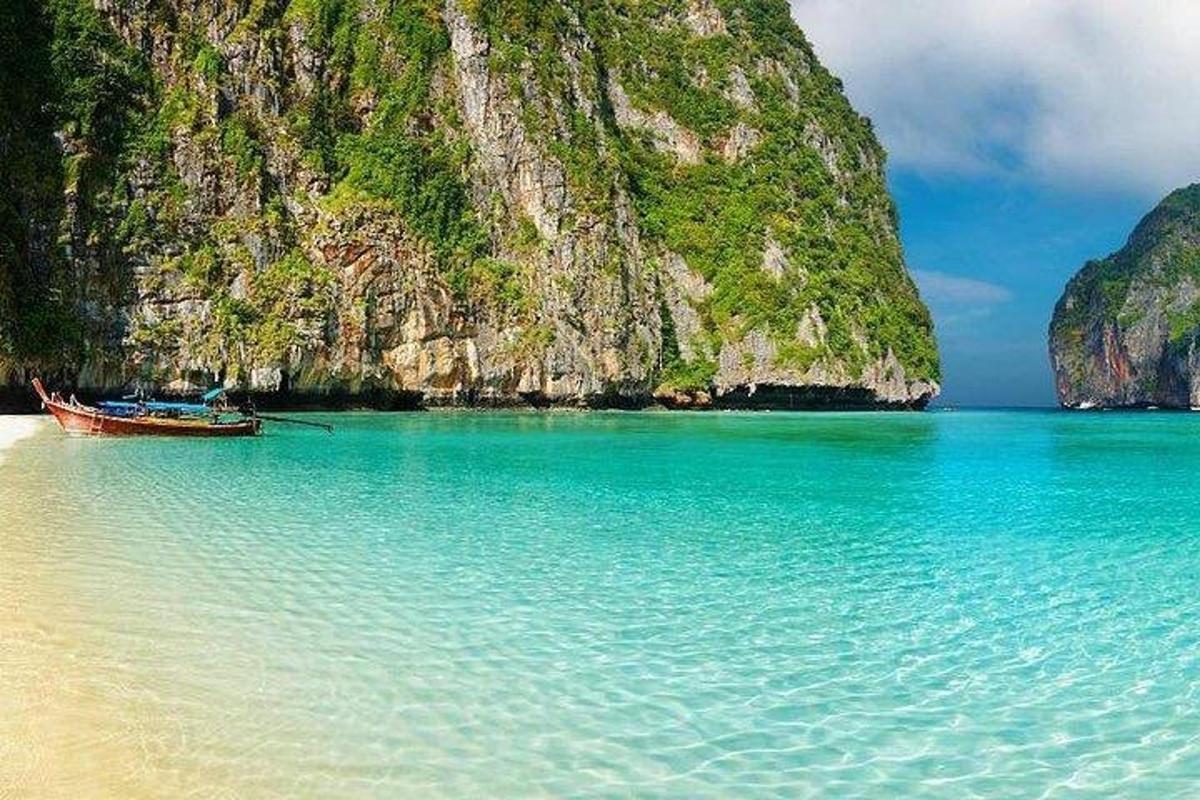 um barco parado na praia ao lado de uma montanha