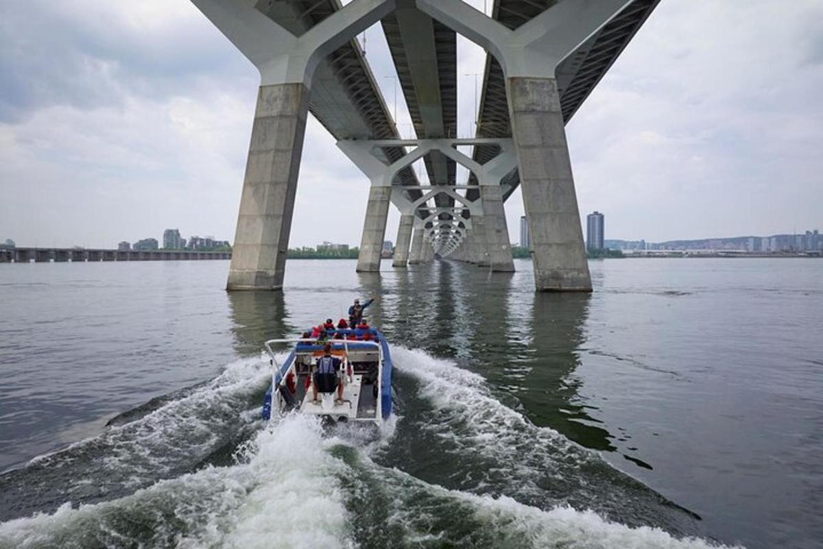 a group of people on a boat under a bridge