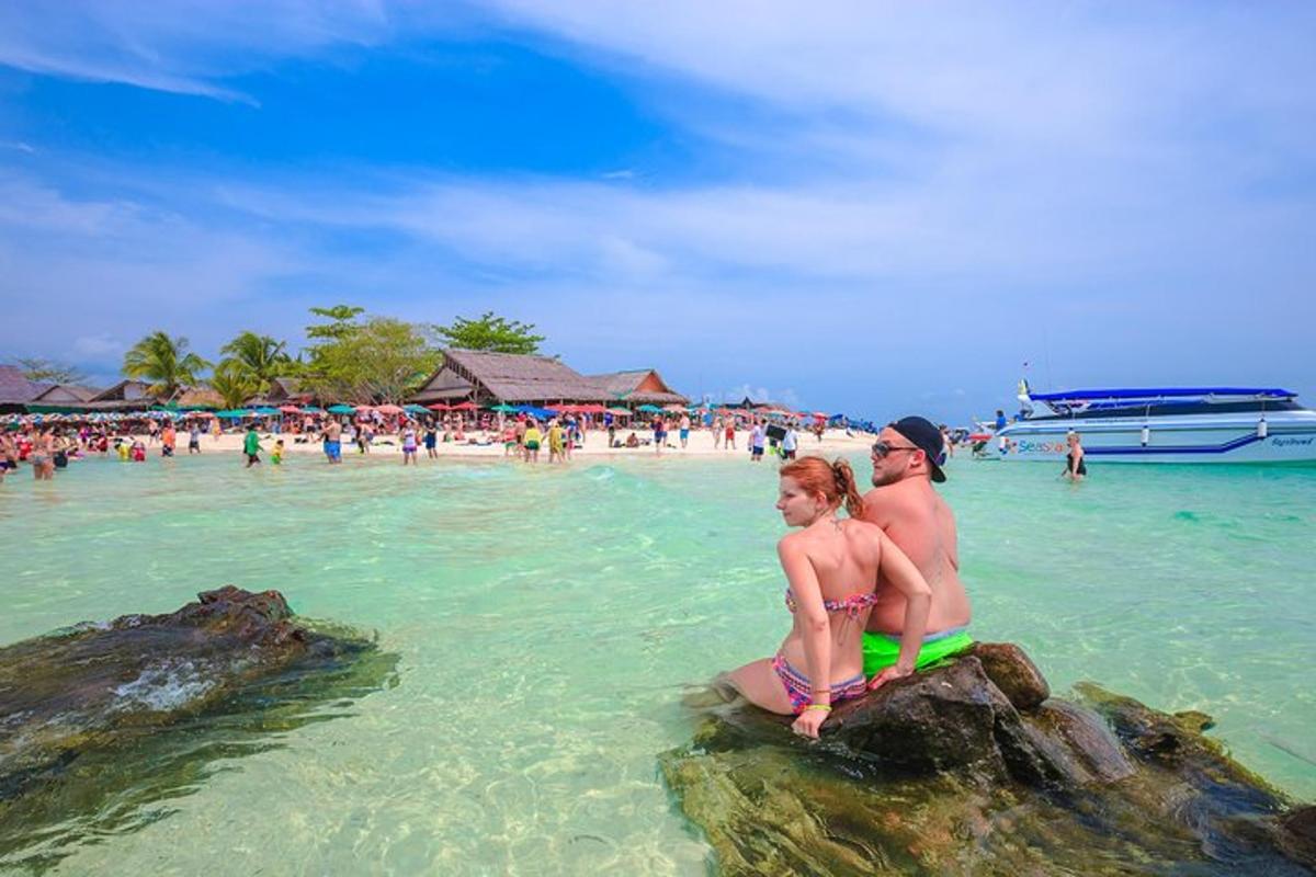 una coppia seduta sulle rocce nell'acqua di una spiaggia