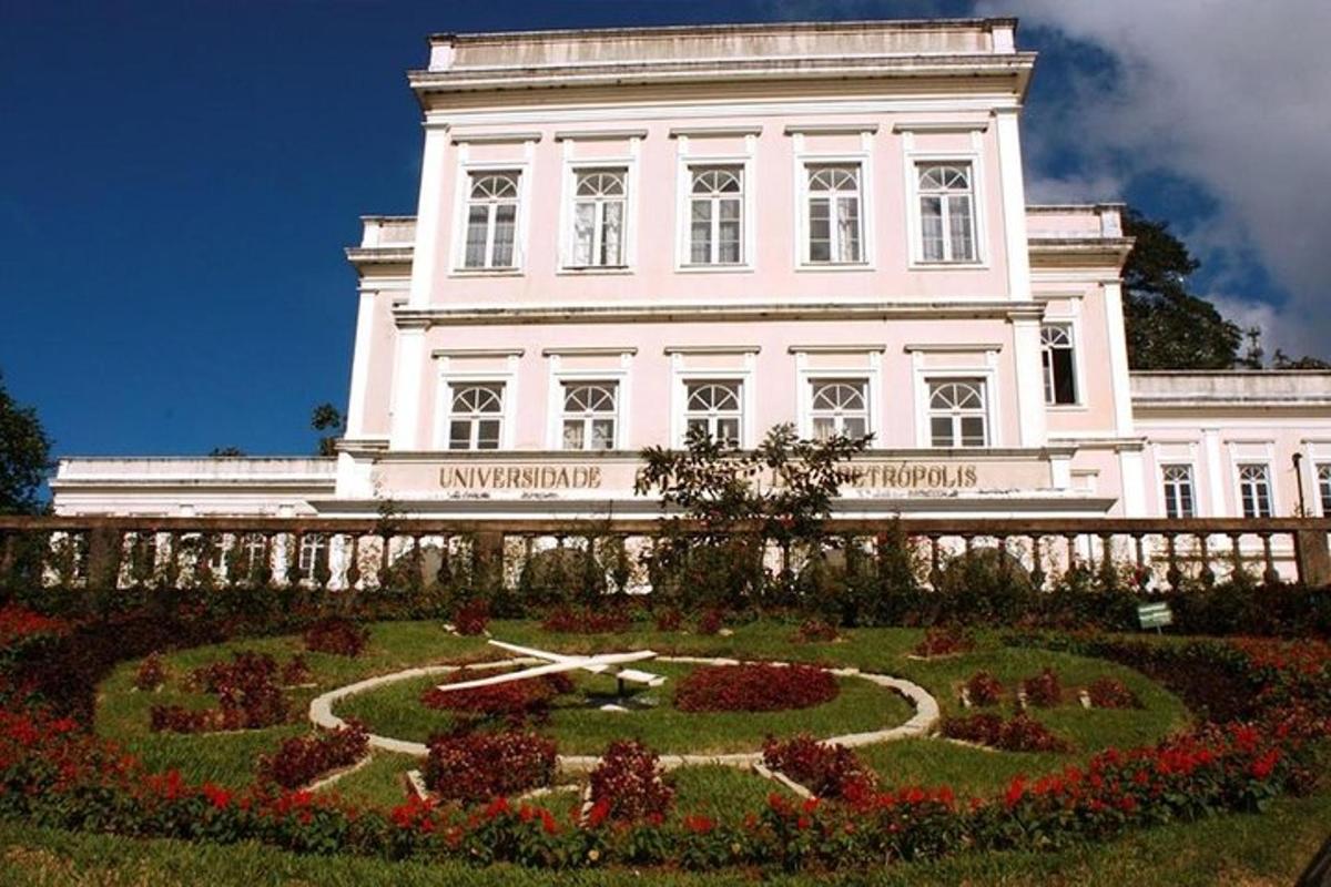 a large white building with a clock in a garden