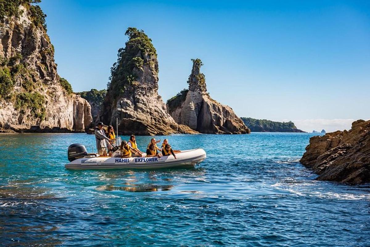 a group of people on a boat in the water with cliffs