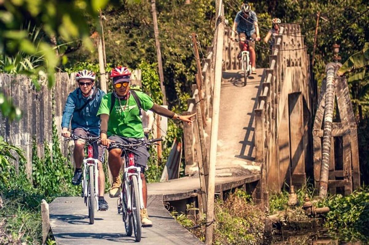 două persoane mergând cu bicicleta pe un pod