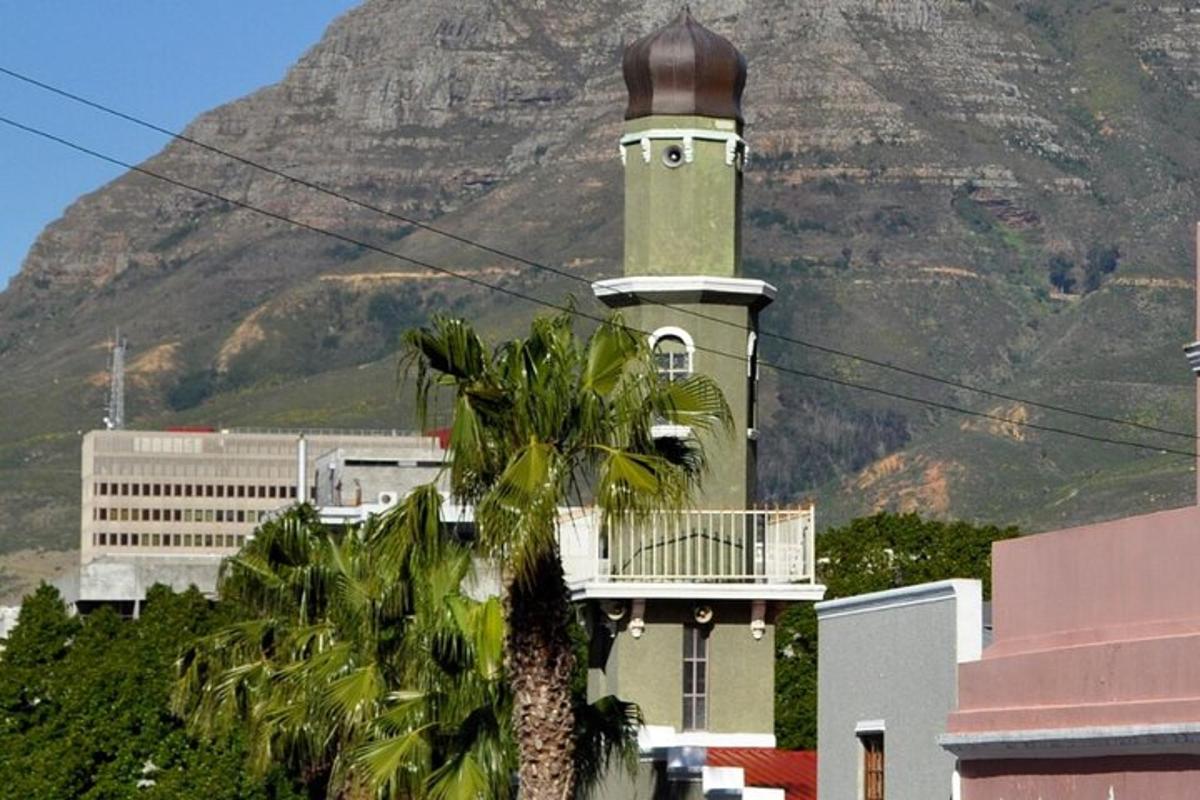 un edificio con una torre dell'orologio di fronte a una montagna