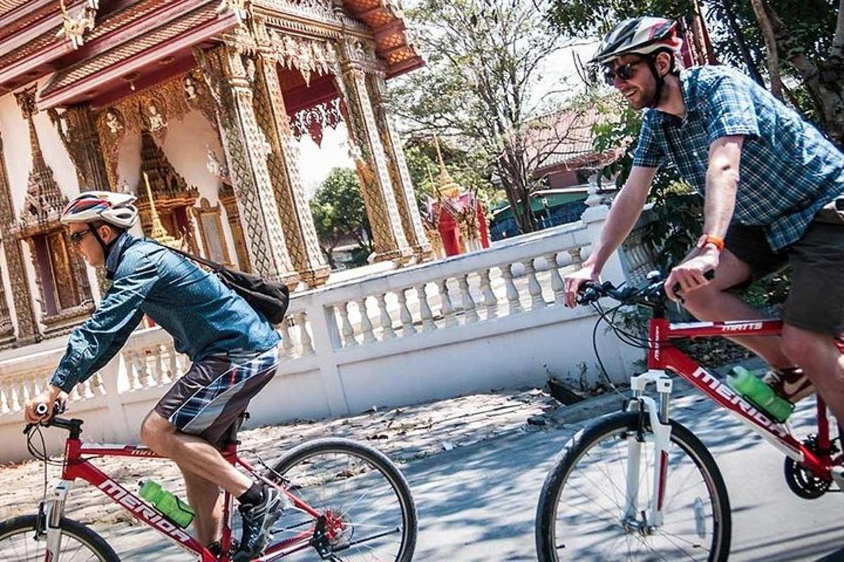 un bărbat care merge pe o bicicletă roșie lângă un băiat