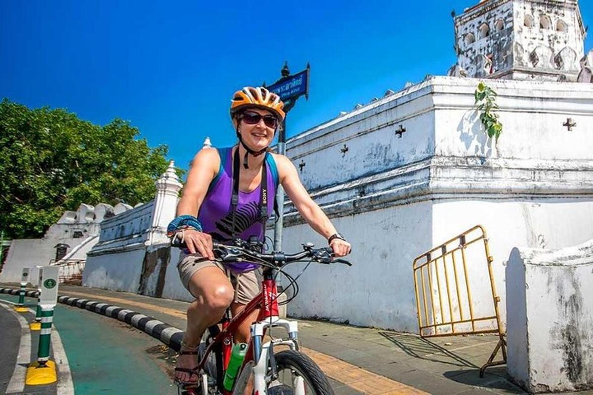 un bărbat care merge cu bicicleta în fața unei clădiri